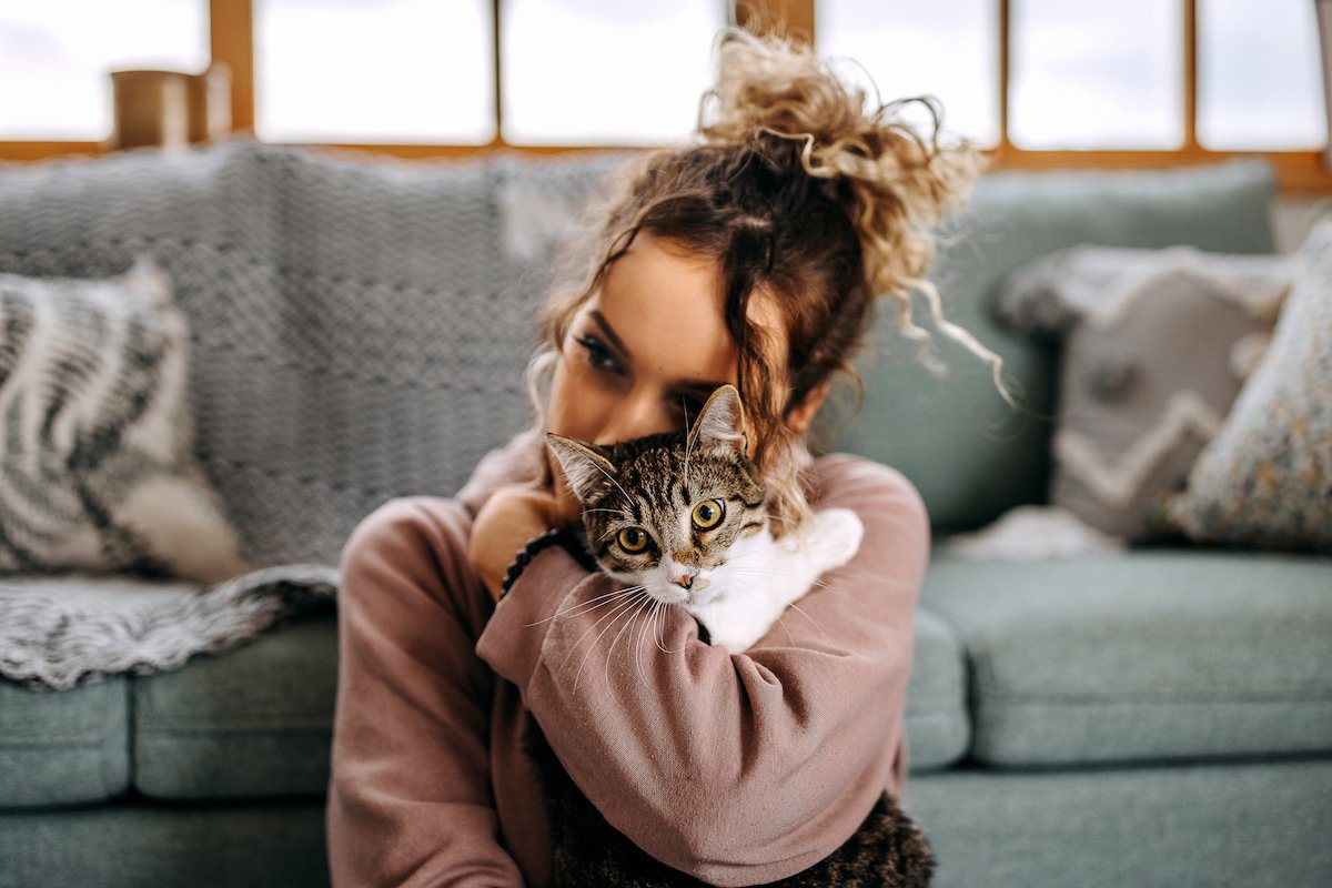 Young woman bonding with her cat in apartment