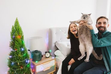 cat and owners at christmas tree