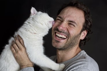 cat licking man's face