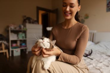 egy nő macskával az ölében