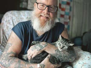 idősebb, demenciában szenvedő férfi macskát ölel