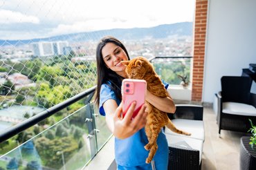 macska egy nővel a lehálózott erkélyen szelfizik