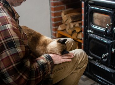 macska és gazdája kályha előtt melegszenek