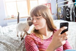 telefonon olvas a macskás nő